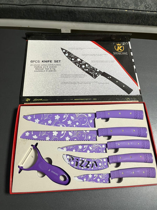 6-piece knife set with purple handles in a box, featuring a peeler, on a dark surface.